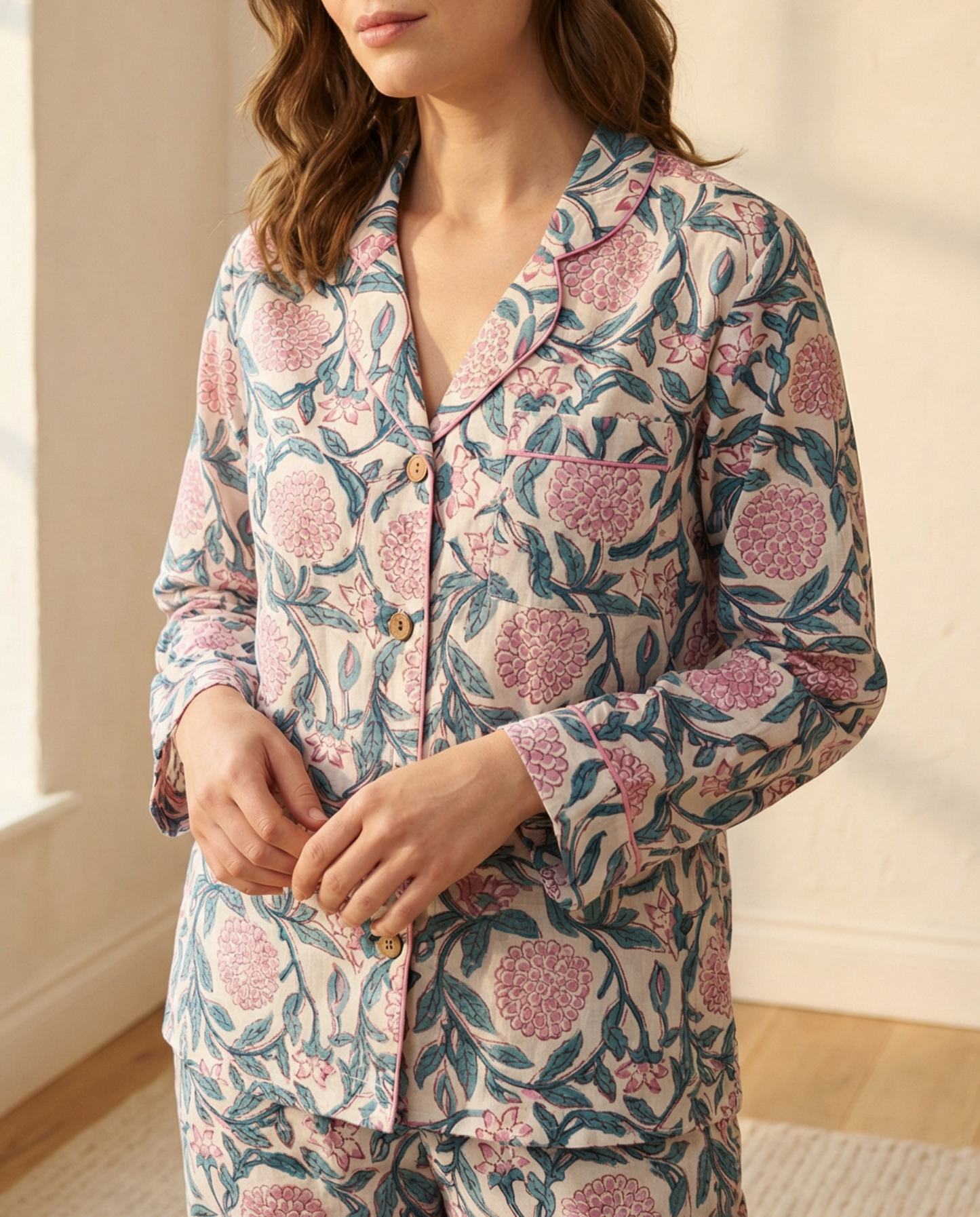 Woman wearing a floral pajama set in a bright room with natural light.